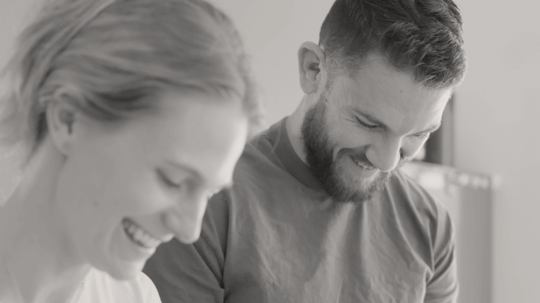 Shoulders up portrait of couple working in the kitchen together.