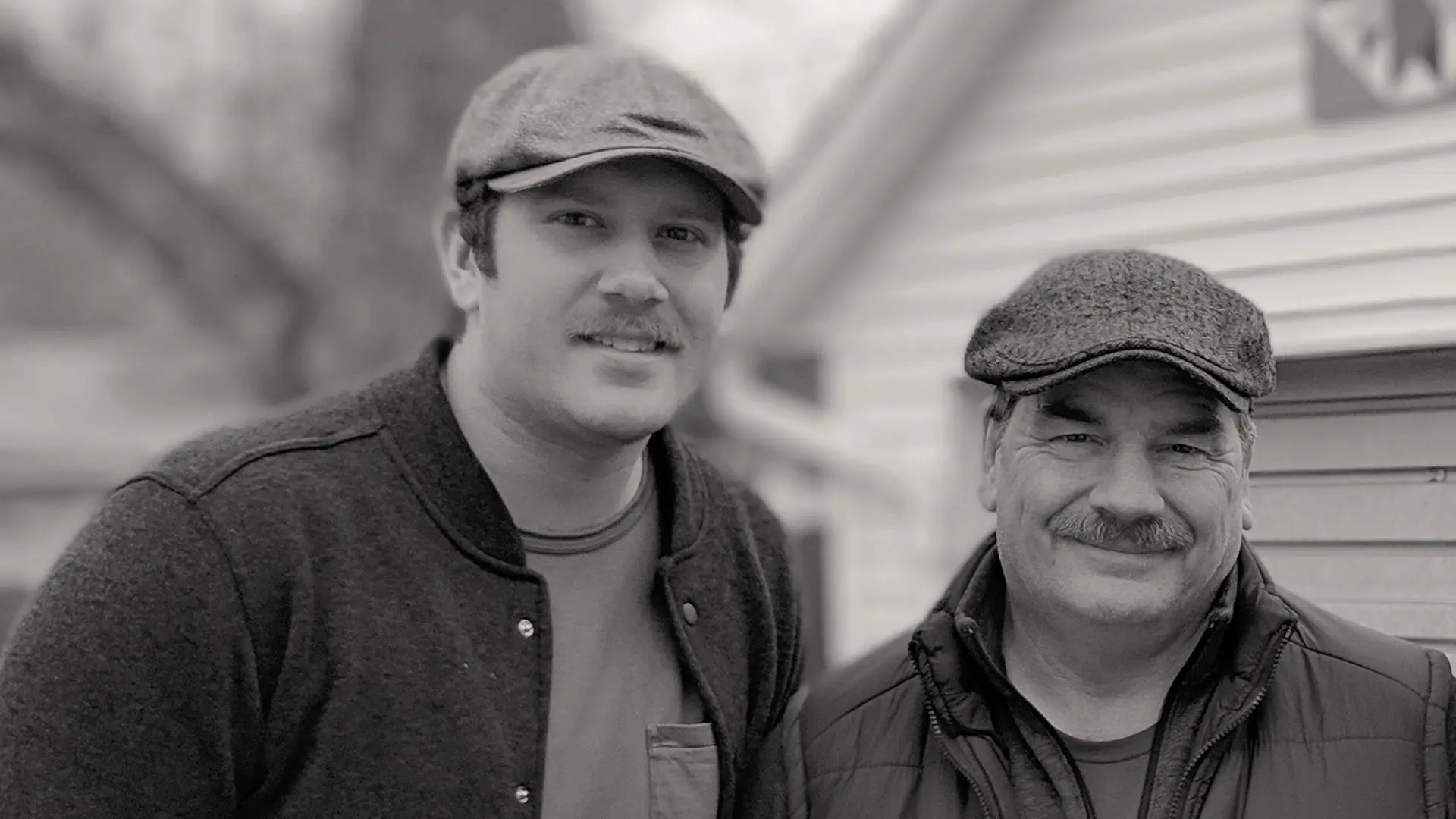 Young man and his father in front of a house